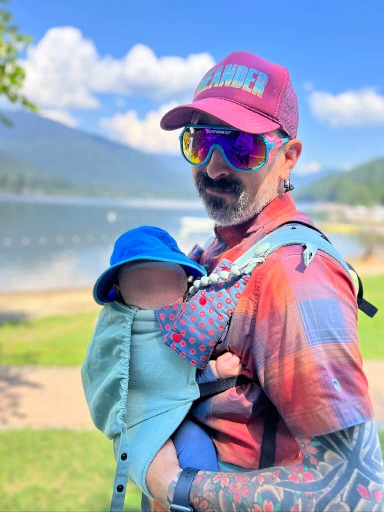 Dad holding baby in a baby carrier. Baby's face is blocked out