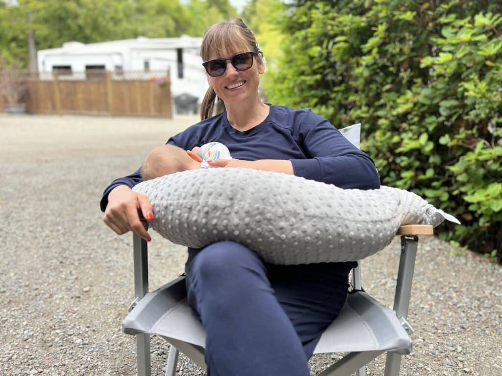 Woman breastfeeding baby at campground