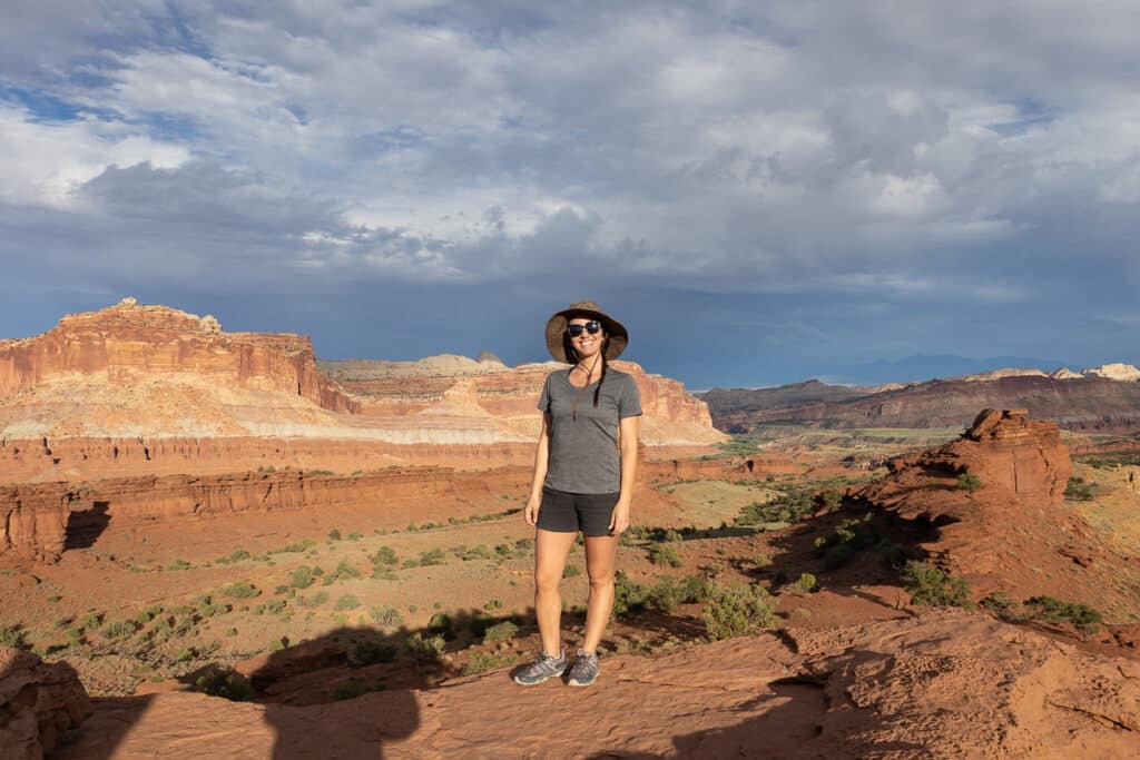 A woman stands at Sunset Point in Capitol Reef National Park in Utah. She's wear Mountain Hardwear Aphrodite Shorts