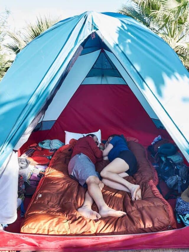 Two people in tent lying on top of double sleeping bag