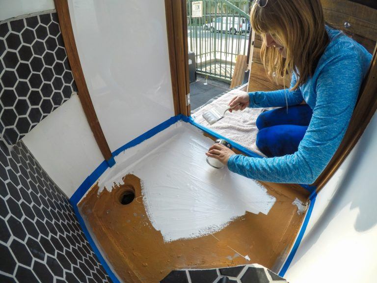 A woman installs a shower in her camper van