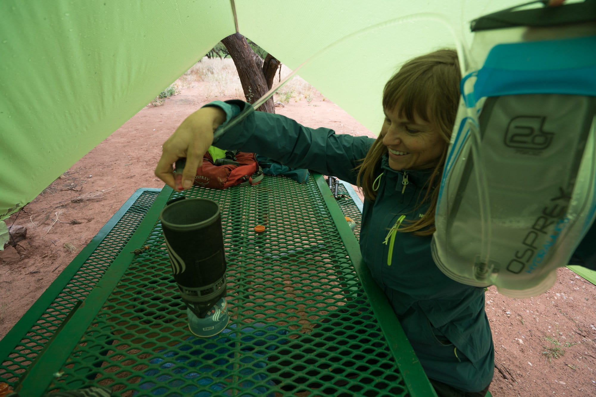Kristen filling Jetboil backpacking stove on picnic table at Havasu Falls campsite from hydration water reservoir