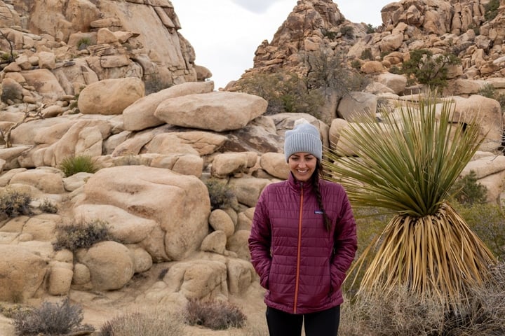 Girl wearing a pink Patagonia Nano Puff surrounded by rocks a hike in Joshua Tree