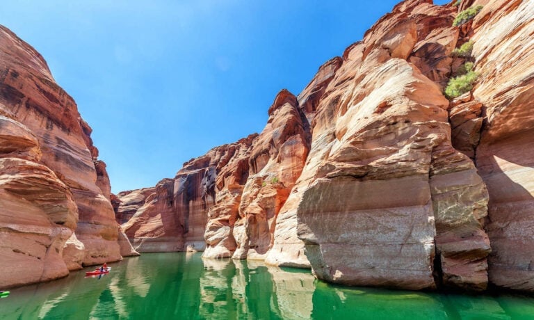 Kayakers on green colored water on Powell Lake in Arizona