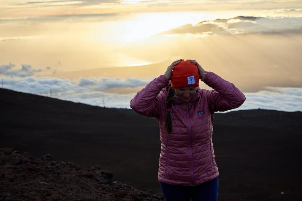 Bearfoot Theory founder Kristen Bor on the summit of Maui's Haleakala for sunset wearing a Patagonia Nano Puff Jacket