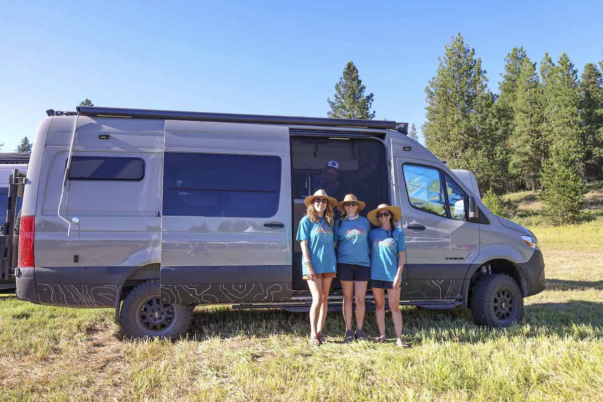 Three women standing in front of a Sprinter van at Open Roads Fest