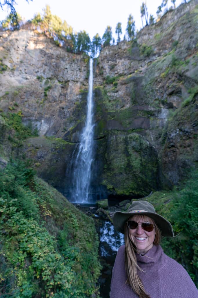 Woman standing in front of Multnomah Falls in Oregon