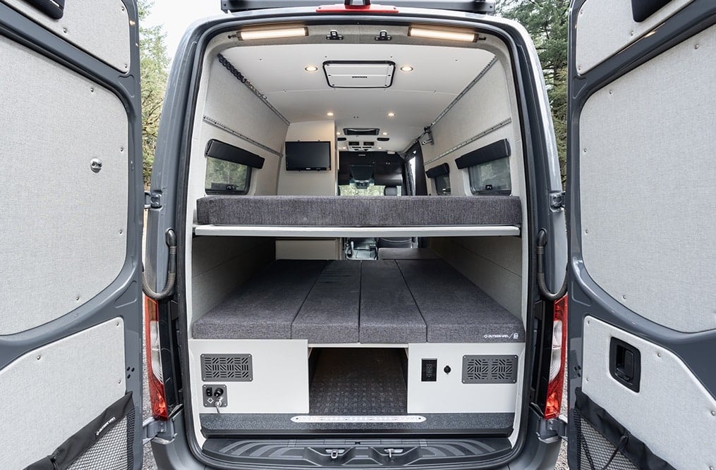 Inside of Outside Van's Approach Model Van. Photo is taken from the back of the van and shows two platform beds on top of one another that can sleep four people