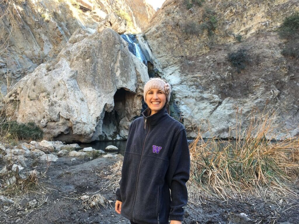 Woman standing in front of small waterfall on a hike outside of Los Angeles, California
