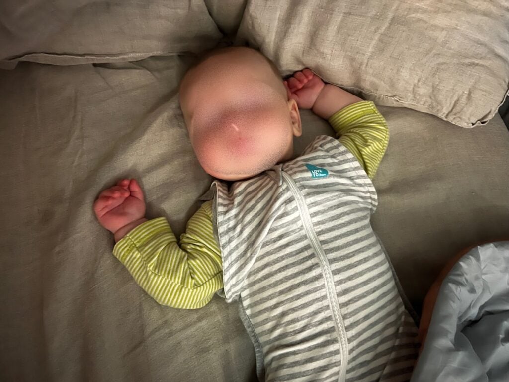 Baby sleeping in a Sprinter Van. Baby's face is blocked out