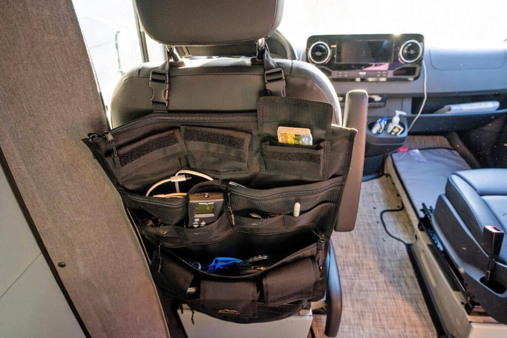 Overland Gear Guy Sprinter III Seat Organizer on the back of the drivers seat in a Sprinter Van