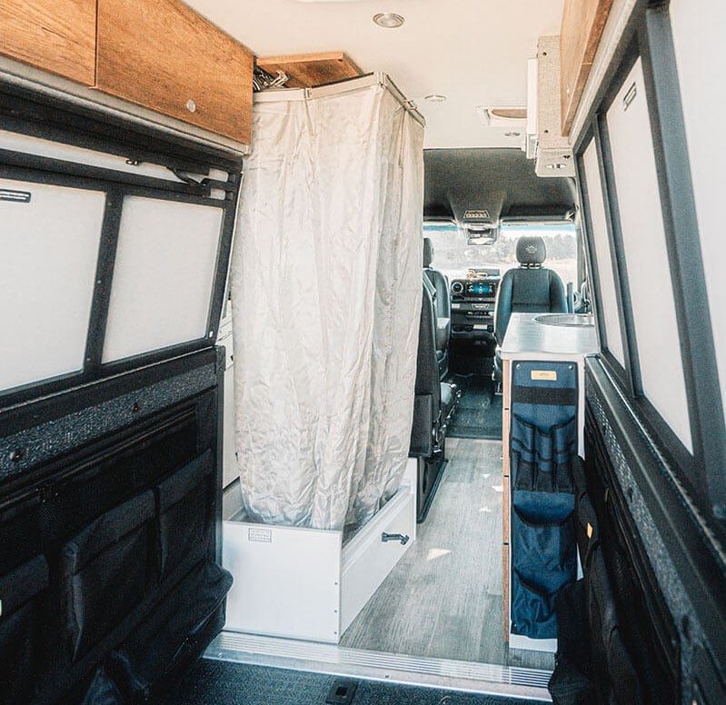 Stowable camper van bathroom setup with indoor shower by @storytelleroverland