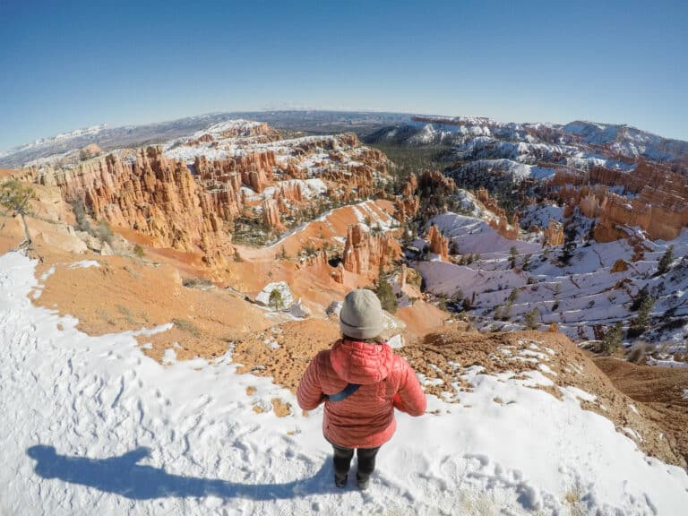 Woman standing on the rim of Bryce Canyon national park in winter after a snowstorm