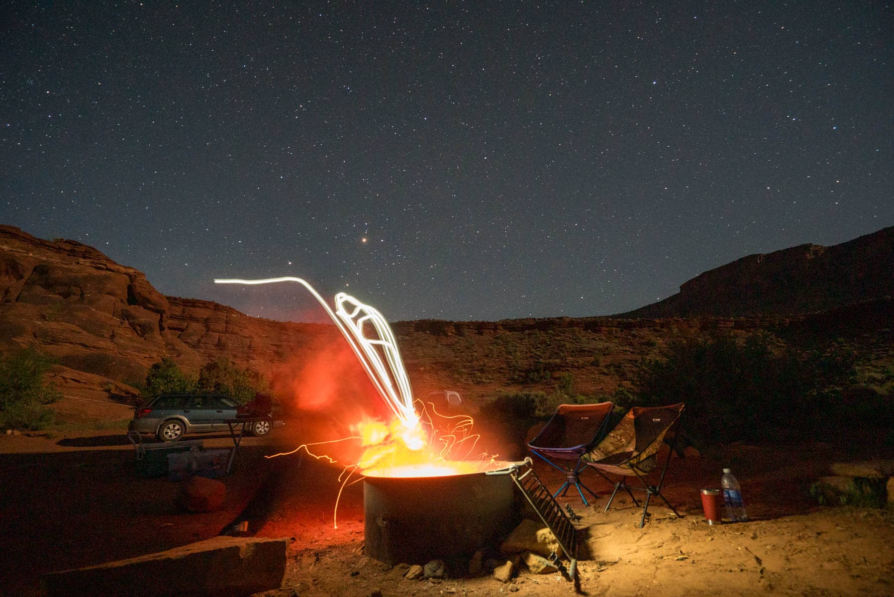 Campfire under a starry sky in the Utah desert