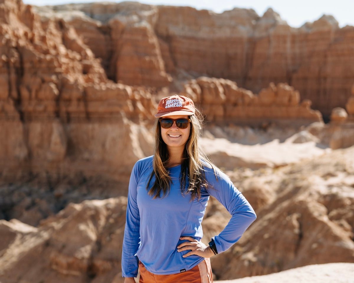 Female hiker posing for a photo on the Goblin's Lair trail in Goblin Valley State Park in Utah