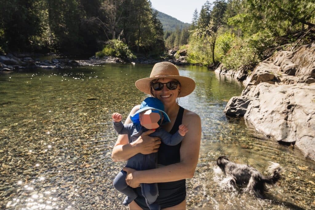 Mom holding baby next to a river