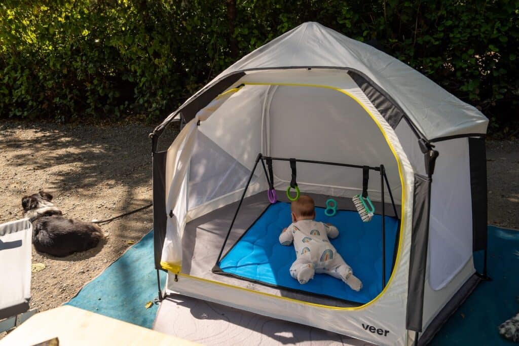Baby lying on stomach in a state tent set up at a campsite