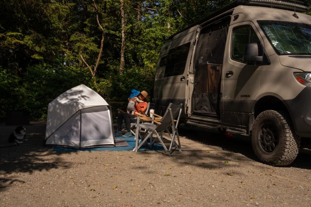 Kristen, BFT Founder, holding her baby in a Dometic GO Compact Camping Chair at camp in British Columbia