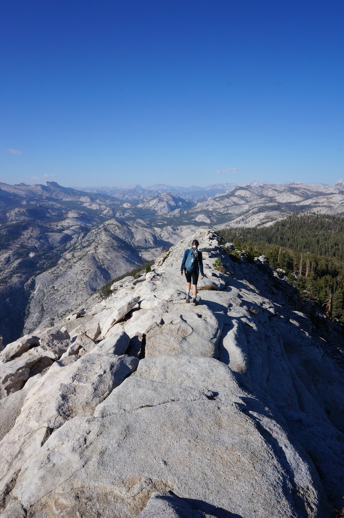 Woman hiking on knife ridge of the Clouds Rest Trail in Yosemite